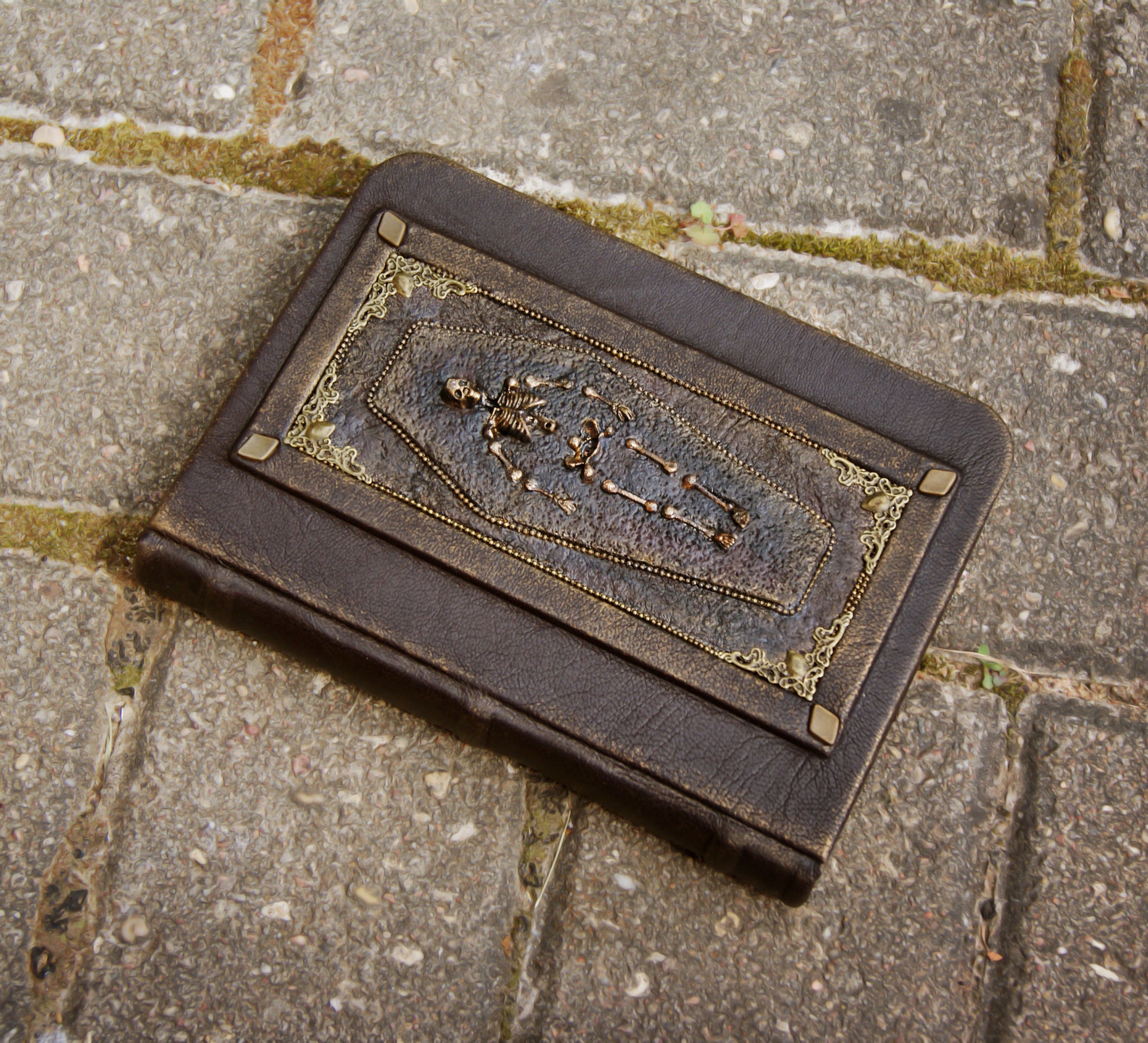 Decorative leather journal with intricate design on a stone surface