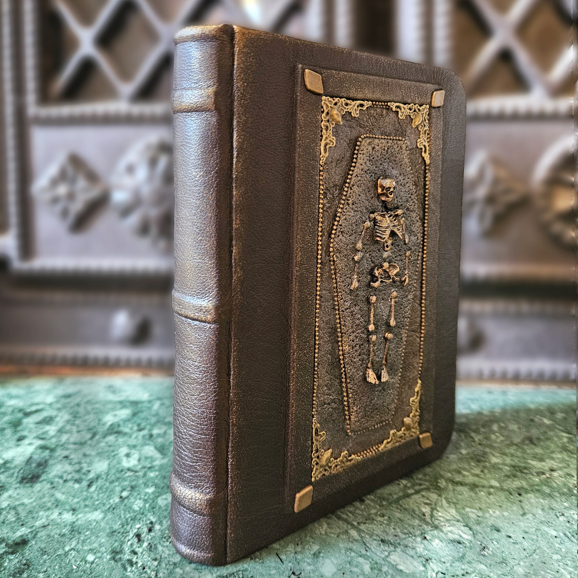 Decorative leather book with skeleton design on a textured surface
