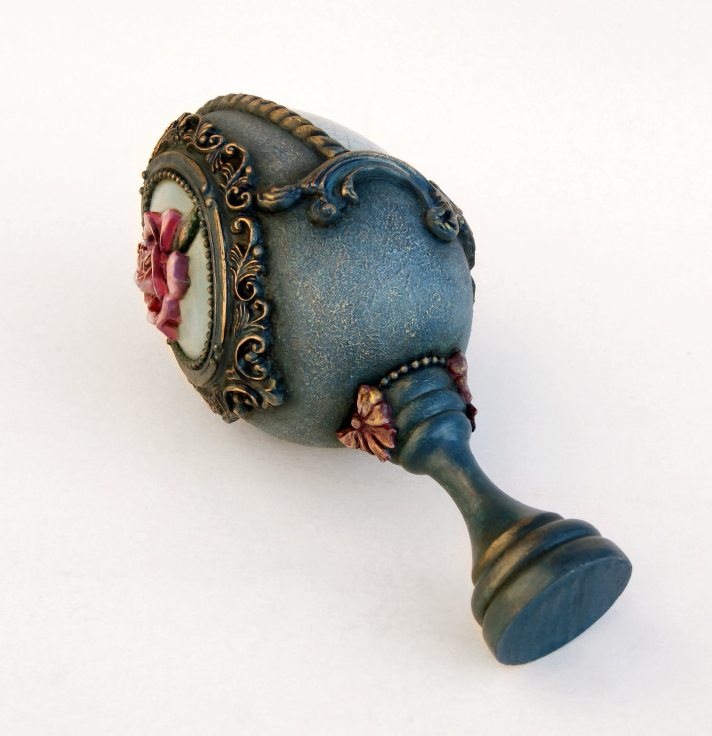 Decorative blue egg with floral design on a white background