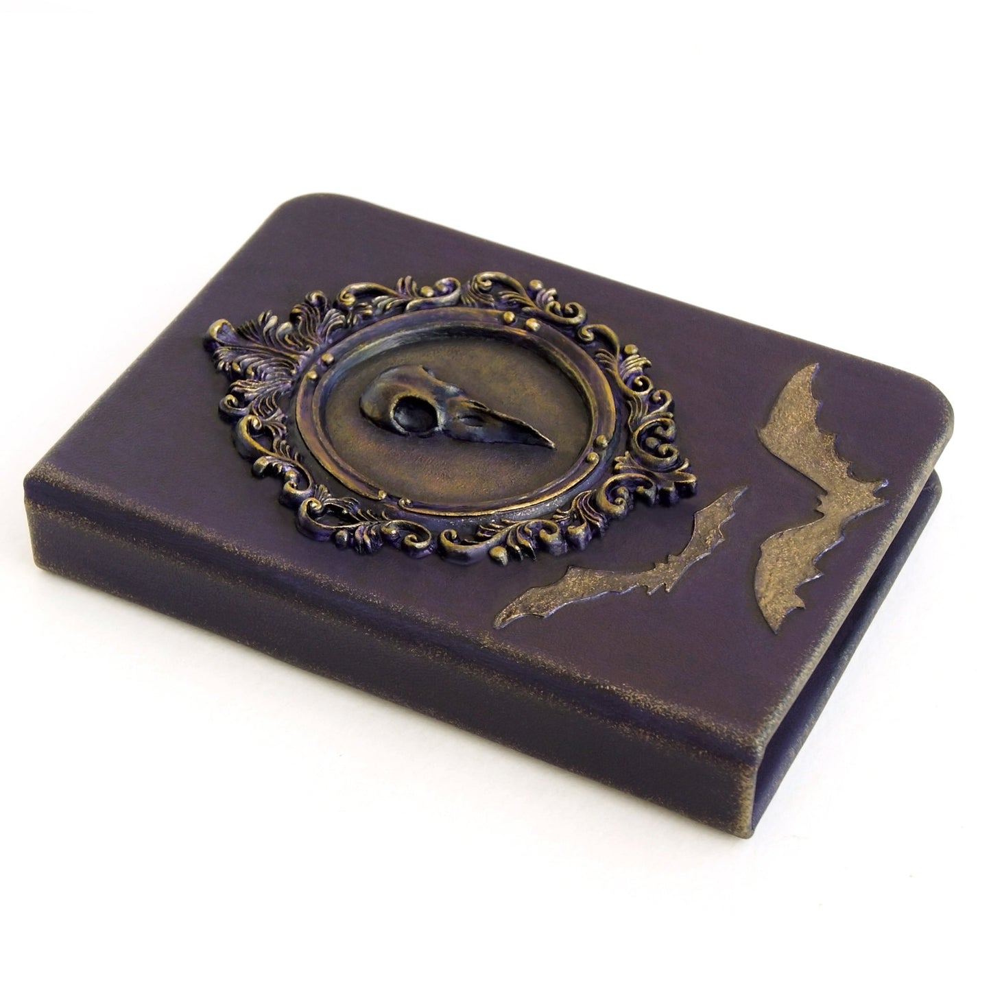 Purple leather notebook with a crow skull in a Victorian frame