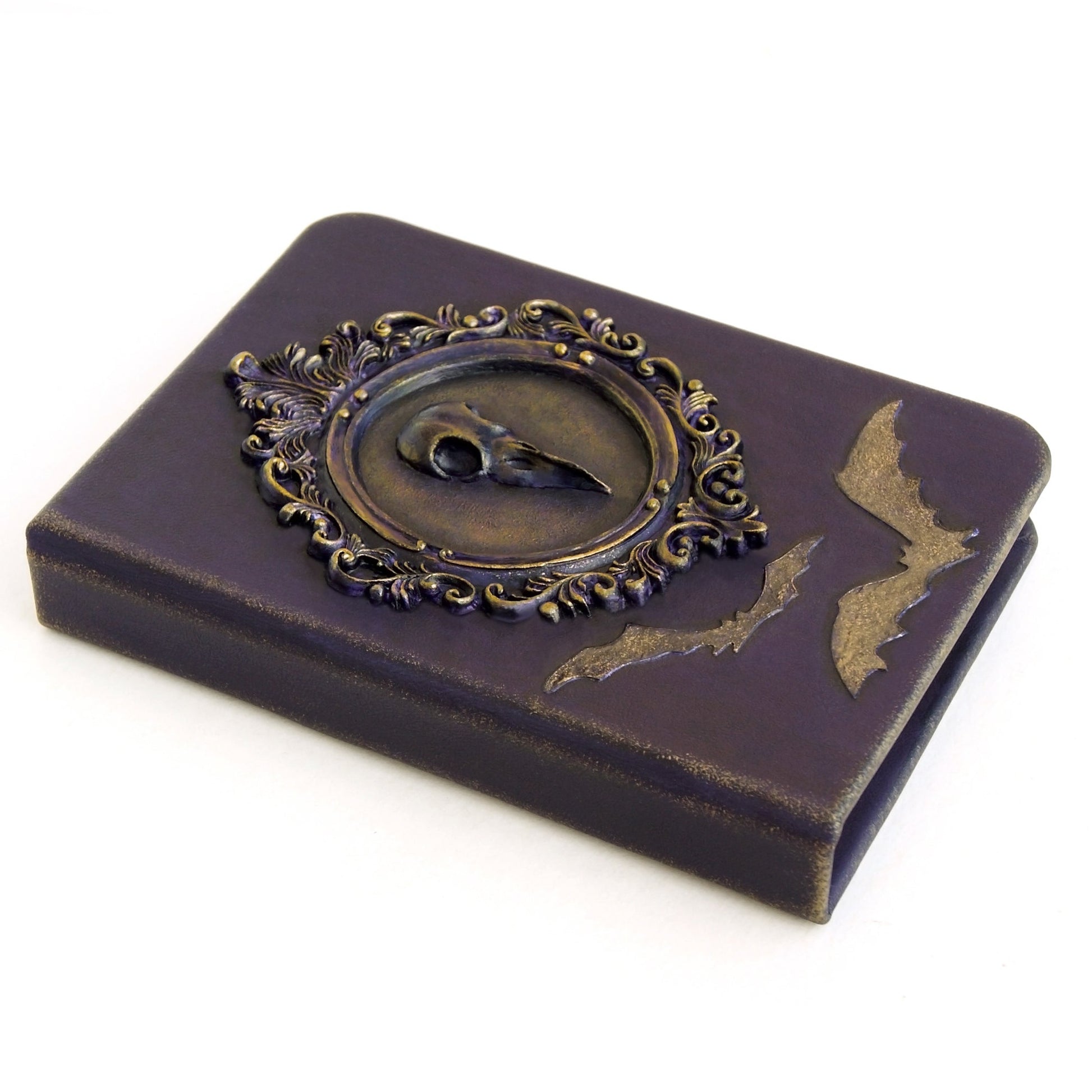 Purple leather notebook with a crow skull in a Victorian frame