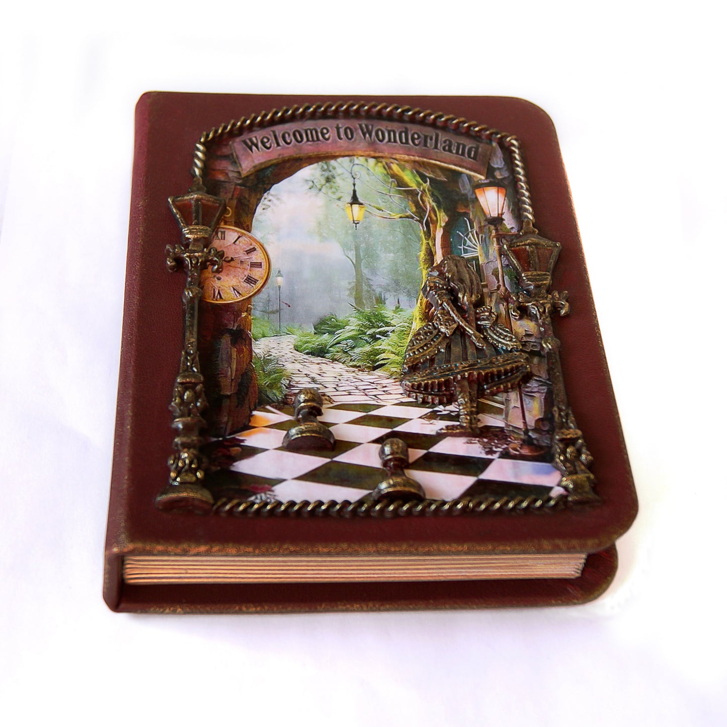 Decorative book with a Wonderland-themed cover featuring a checkered floor and fantasy landscape.