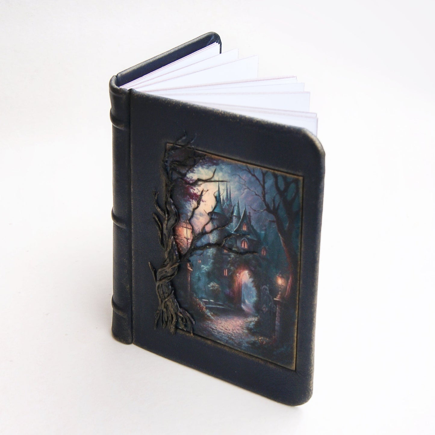 Handmade leather journal.On the cover there is a tree made of polymer clay and a mysterious castle in the forest. Image placed on polymer clay.